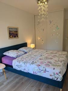 - une chambre avec un lit et un lustre dans l'établissement EDEN GOLFE Plages à pieds Parking Privé, à Vallauris