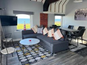 uma sala de estar com um sofá e uma mesa em Lifeboat House em Skerries