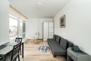 a living room with a couch and a table at Zalgirio Arena Apartment No1 by URBAN RENT in Kaunas