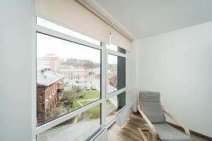 a white room with two chairs and a large window at Zalgirio Arena Apartment No1 by URBAN RENT in Kaunas
