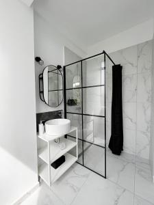 a white bathroom with a sink and a mirror at Town Spot - Premium Studio - Sanador Victoriei in Bucharest