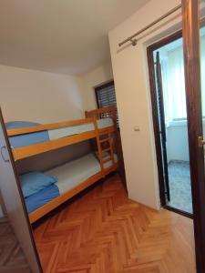 Apartment in Budva في بودفا: غرفة بسريرين بطابقين وباب