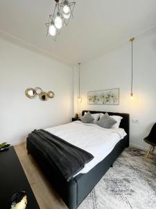 Un dormitorio con una gran cama negra en una habitación blanca en Town Spot - Premium Studio - Sanador Victoriei, en Bucarest