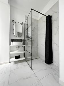 y baño con ducha acristalada y lavamanos. en Town Spot - Premium Studio - Sanador Victoriei, en Bucarest