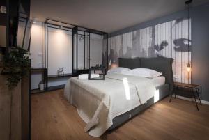a bedroom with a large white bed and some windows at Sibinicum luxury rooms in Šibenik