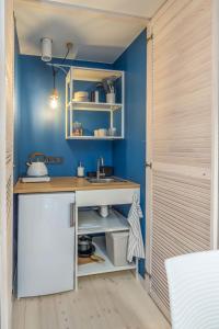 a kitchen with blue walls and a sink at B2 Apartments in Klaipėda