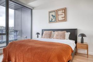 um quarto com uma cama grande e um cobertor laranja em South Lake Union 2br w gym roof nr restaurants SEA-554 em Seattle