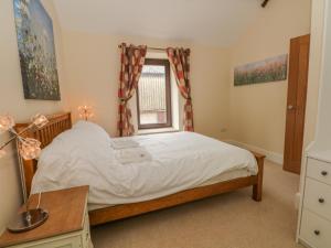 a bedroom with a bed and a window at Swallows Return in Macclesfield