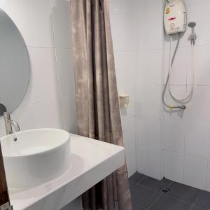 ein Bad mit einem Waschbecken und einer Dusche in der Unterkunft Jomtien Hostel 3 in Jomtien Beach