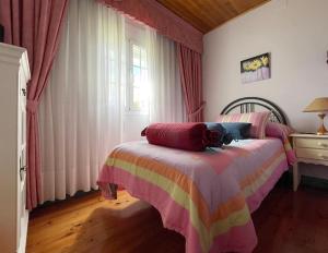 Batallanes的住宿－Casa Rural O Petisco，一间卧室,卧室里配有一张床,猫坐在床上