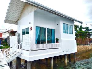 uma casa branca numa doca na água em Baan I Talay On Sea Koh Larn em Ko Larn