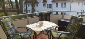 齊諾維茨的住宿－Ostseeoase Zinnowitz，阳台上的桌椅,上面有杯子
