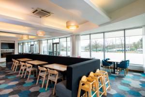 a restaurant with tables and chairs and windows at Holiday Inn Express Hamilton, an IHG Hotel in Hamilton