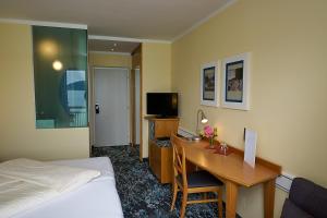 una camera d'albergo con scrivania e letto di Hotel Seewirt a Maria Wörth