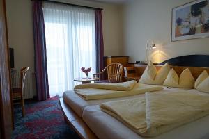 a hotel room with a large bed with pillows at Hotel Seewirt in Maria Wörth