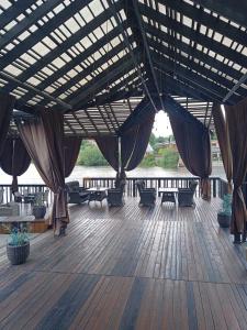 un padiglione con tavoli e sedie su una terrazza in legno di Rikabar Restaurant & nature a Bila Cerkva