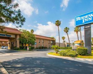 a road in front of a hotel with a sign at Palm Inn Hotel near Tyler Mall Riverside in Riverside