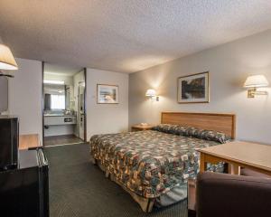 a hotel room with a bed and a table at Palm Inn Hotel near Tyler Mall Riverside in Riverside