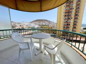 プラヤ・デ・ラス・アメリカスにあるTorres del Solのテーブルと椅子2脚、景色を望むバルコニー