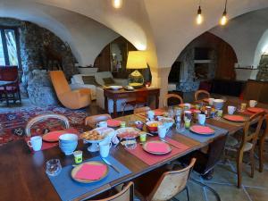 una gran mesa de madera con comida encima. en La Bergerie à Menée, en Châtillon-en-Diois