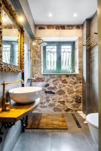 a bathroom with a sink and a mirror at Queen's stone legend, royal living by Acropolis in Athens