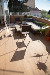 a patio with two chairs and a table on a deck at Alojamientos Puerta Palma con vistas y Parking in Badajoz