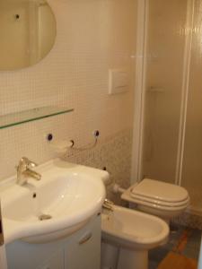 bagno con lavandino, servizi igienici e specchio di Residence Ammiraglia Baia Verde a Gallipoli