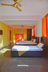 a bedroom with two beds and a ceiling fan at Tapovan Resort in Rishīkesh