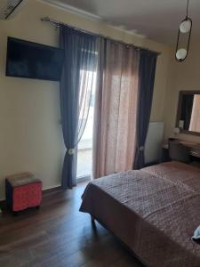 un dormitorio con una cama y una ventana en Valentina's Luxe Apartment, en Mastichari