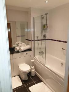 a bathroom with a shower and a toilet and a tub at Birmingham Garnet 3-bedroom Apartment City Centre in Birmingham