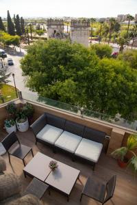 eine Terrasse mit einem Sofa, Stühlen und einem Tisch in der Unterkunft Puerta Palma con vistas únicas y aparcamiento in Badajoz