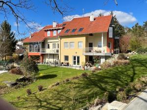 ein großes Haus mit rotem Dach in der Unterkunft Ferienwohnungen Pesenbachtal in Herzogsdorf