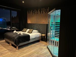 a bedroom with a bed and a glass wall at SO CHIC - Le Domaine Wambrechies in Wambrechies