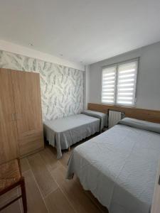una camera con due letti e una finestra di Casa Yeya a Santander