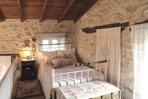 a bedroom with a bed in a stone wall at "Thimises" traditional-stone village house in Kharasón