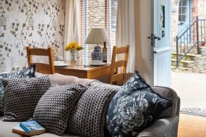 a couch with pillows on it in a living room at Puffin Cottage in Ilfracombe