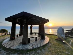 a dog laying under a pavilion next to the ocean at 20ft Sea Attic in Green Island
