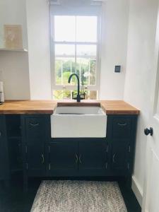 une cuisine avec un évier et une fenêtre dans l'établissement Galashiels Town Centre Cottage Sleeps 2, à Galashiels