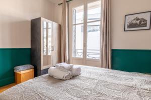 1 dormitorio con 1 cama grande y ventana grande en *LarDéco* Central ville & Parking, en Clermont-Ferrand
