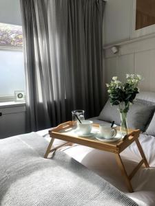 une table basse avec un vase de fleurs sur un lit dans l'établissement Galashiels Town Centre Cottage Sleeps 2, à Galashiels