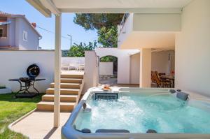 a hot tub in the backyard of a house at Villa Mali Raj in Lopar