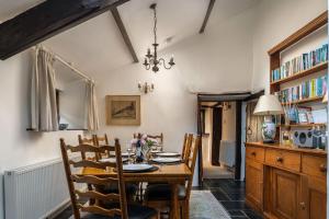 a dining room with a wooden table and chairs at Honey Buzzard Farmhouse in Ilfracombe