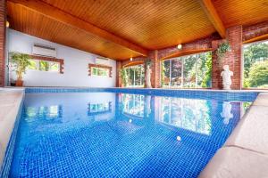 a swimming pool in a house with a wooden ceiling at Honey Buzzard Farmhouse in Ilfracombe