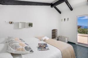 a white bedroom with a bed and a large window at Villa Mali Raj in Lopar +20 photos