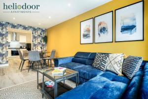 a living room with a blue couch and a table at HAL Heliodoor Apartments Milton Keynes, Free Parking, Free WiFi & Movies, 7-min drive to City Centre in Wolverton