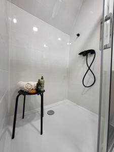 biała łazienka z prysznicem i stołem w obiekcie Jázminka alpesi házikó w mieście Bükkszentkereszt