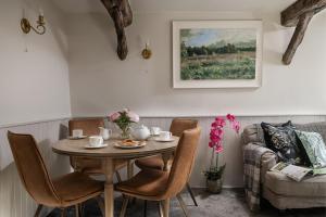 a dining room with a table and chairs and a couch at Rosefinch Cottage in Ilfracombe