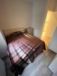 een slaapkamer met een bed met een geruite deken bij BAHÇELİ MÜTHİŞ KONUMDA FERAH DAİRE in Istanbul