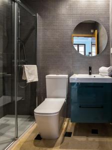 ein Badezimmer mit einem WC, einem Waschbecken und einem Spiegel in der Unterkunft Mesones 54 in Granada