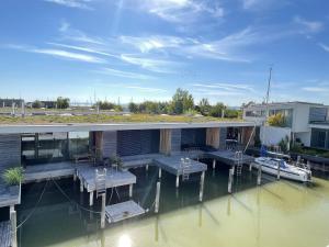 a house on the water with a dock and a boat at Ferienhaus am See Neusiedl in Neusiedl am See